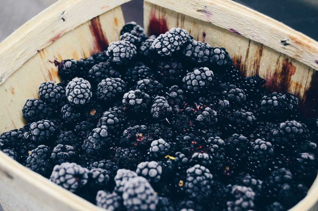 A photograph of a basket of blackberries that look ready to bake into a crumble. 