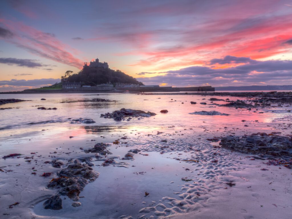 Dramatic sunset on the beach at Marazion with St Michaels Mount in the distance, Cornwall England UK Europe